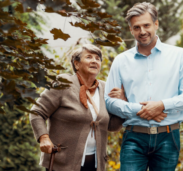 Man and older lady walking in a garden